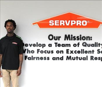 Tech standing in front of our mission statement