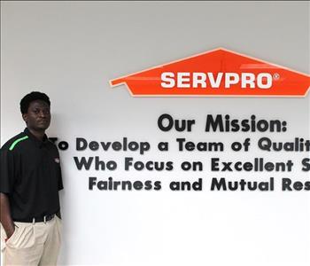 Tech standing in front of our mission statement