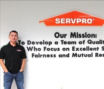 Construction estimator standing in front of our mission statement