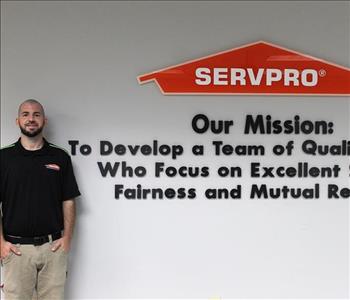 Tech standing in front of our mission statement