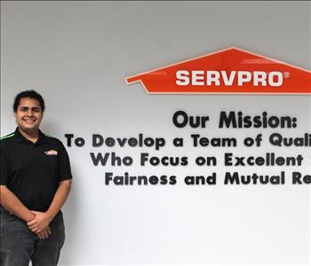 Tech standing in front of our mission statement