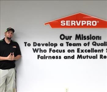 Tech standing in front of our mission statement