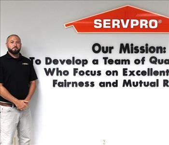 Estimator standing in front of our mission statement