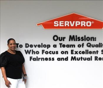 Ops Coordinator standing in front of mission statement