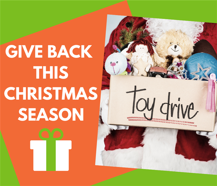 Santa Claus holding Toy Drive Box with toys inside with green back ground and orange box that says give back this Christmas